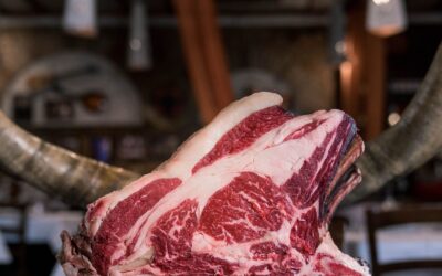 Côte de bœuf, entrecôte, faux-filet : quelles différences ? Côte de bœuf crue persillée posée sur une planche en bois
