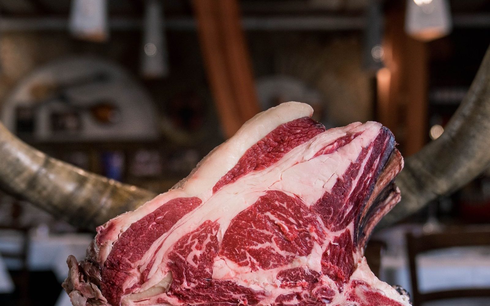Côte de bœuf crue persillée posée sur une planche en bois