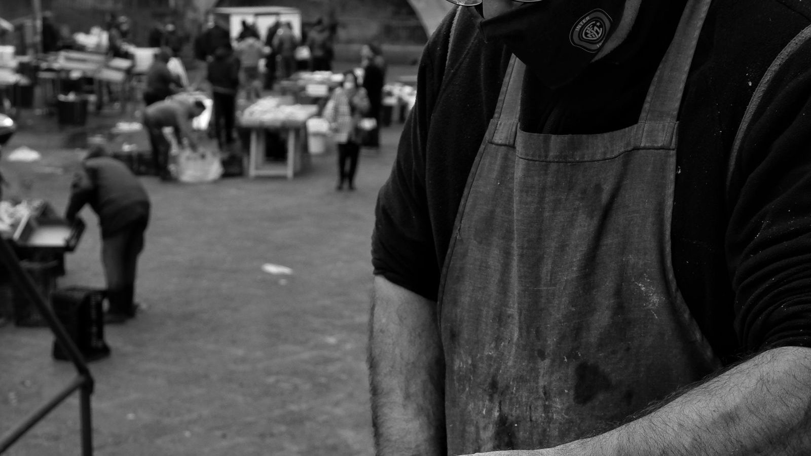 Photographie en noir et blanc des mains d'un boucher au travail