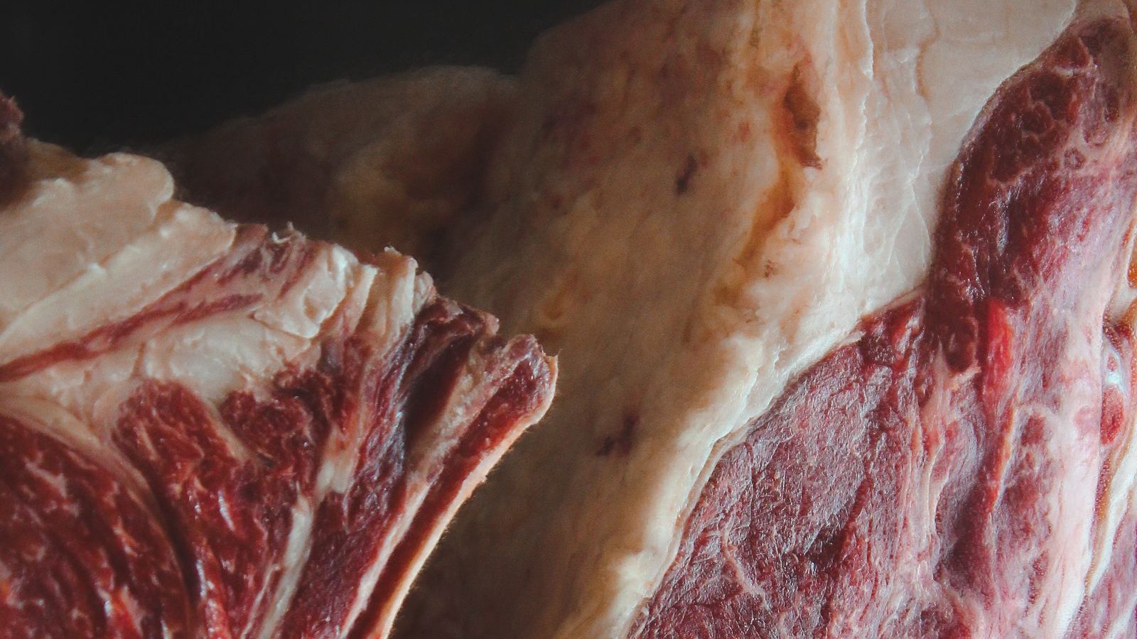 Gros plan sur le persillé et le gras d'une côte de bœuf crue