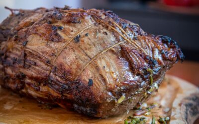 Rôti de bœuf ficelé et doré au four, garni d'herbes