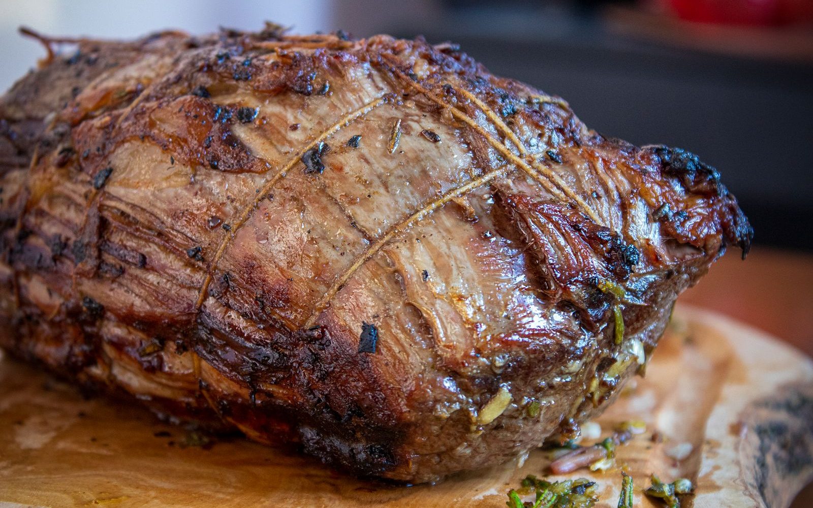 Rôti de bœuf ficelé et doré au four, garni d'herbes