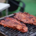 Travers de porc en train de griller sur un barbecue au charbon