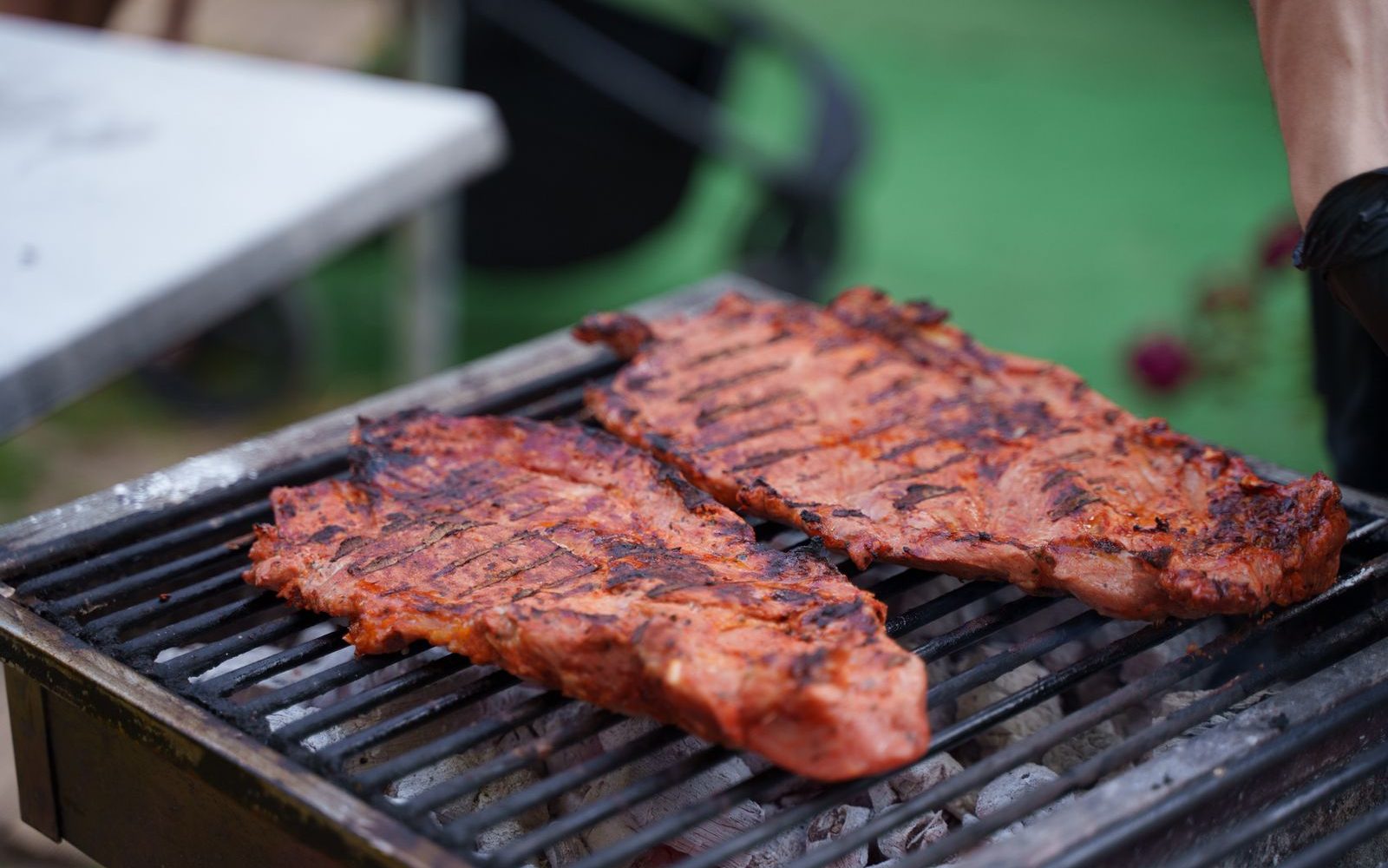 Travers de porc en train de griller sur un barbecue au charbon