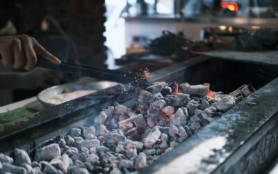 Réussir un barbecue : braises, distance et timing Braises incandescentes sous une grille de barbecue au charbon